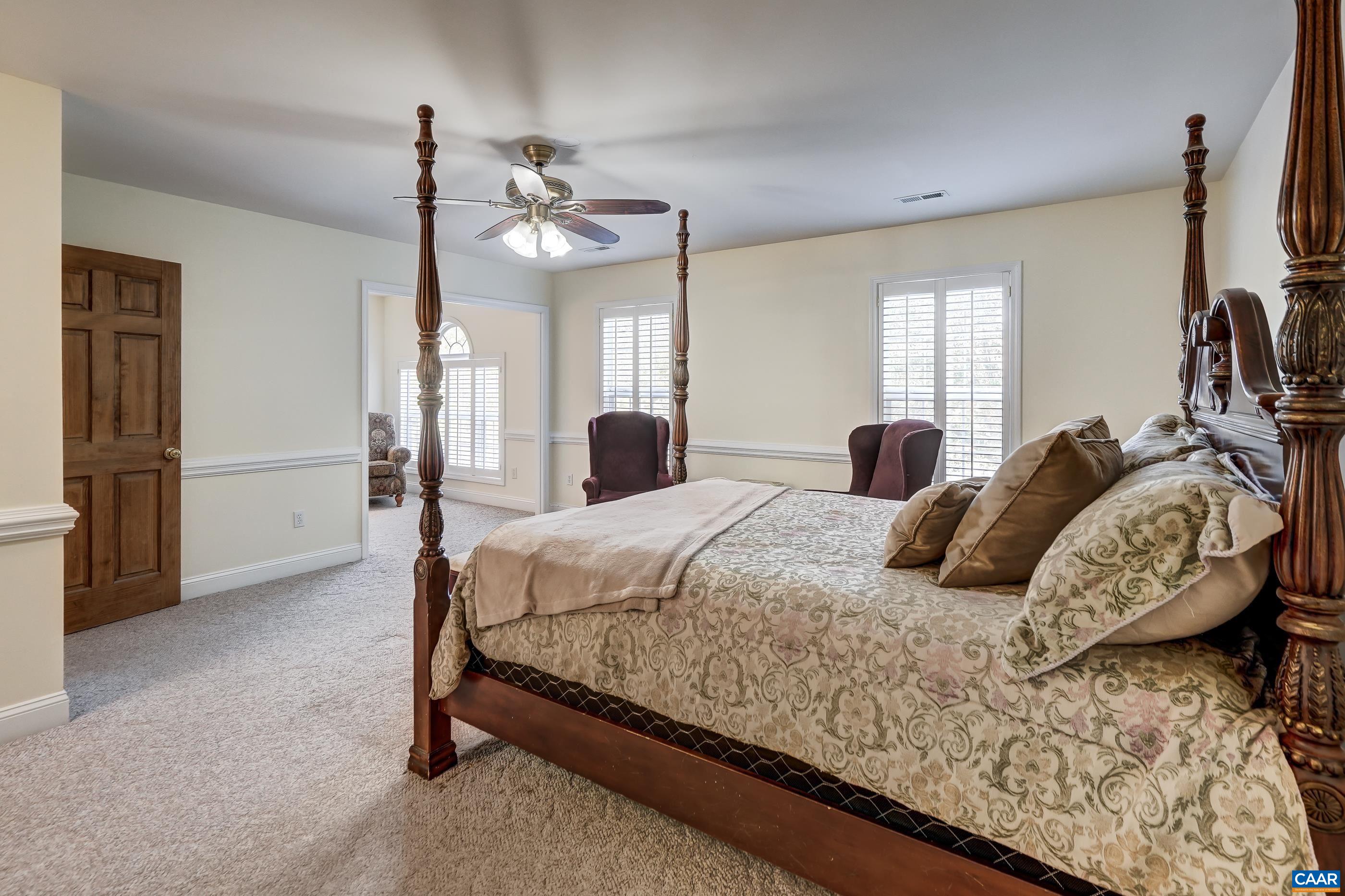 Primary suite with ceiling fan and sitting area. Primary suite with ceiling fan and sitting area.